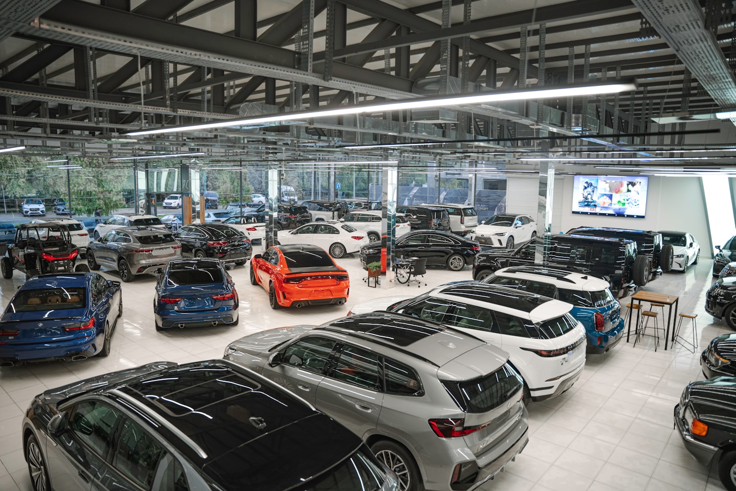 Diverse auto sportive e di lusso riempiono uno showroom moderno e luminoso.