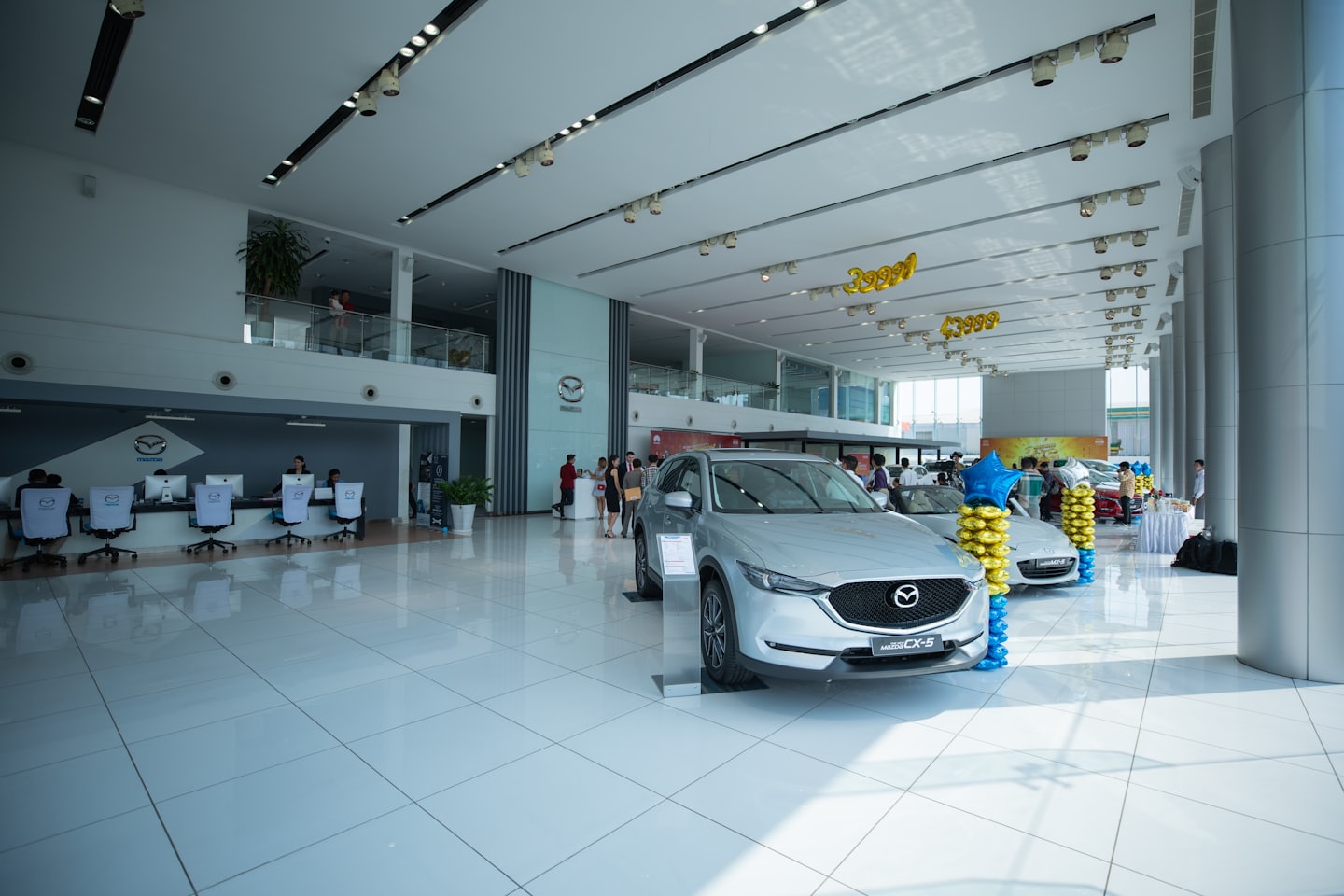 Nuove Mazda argentate esposte in un luminoso showroom di concessionaria.
